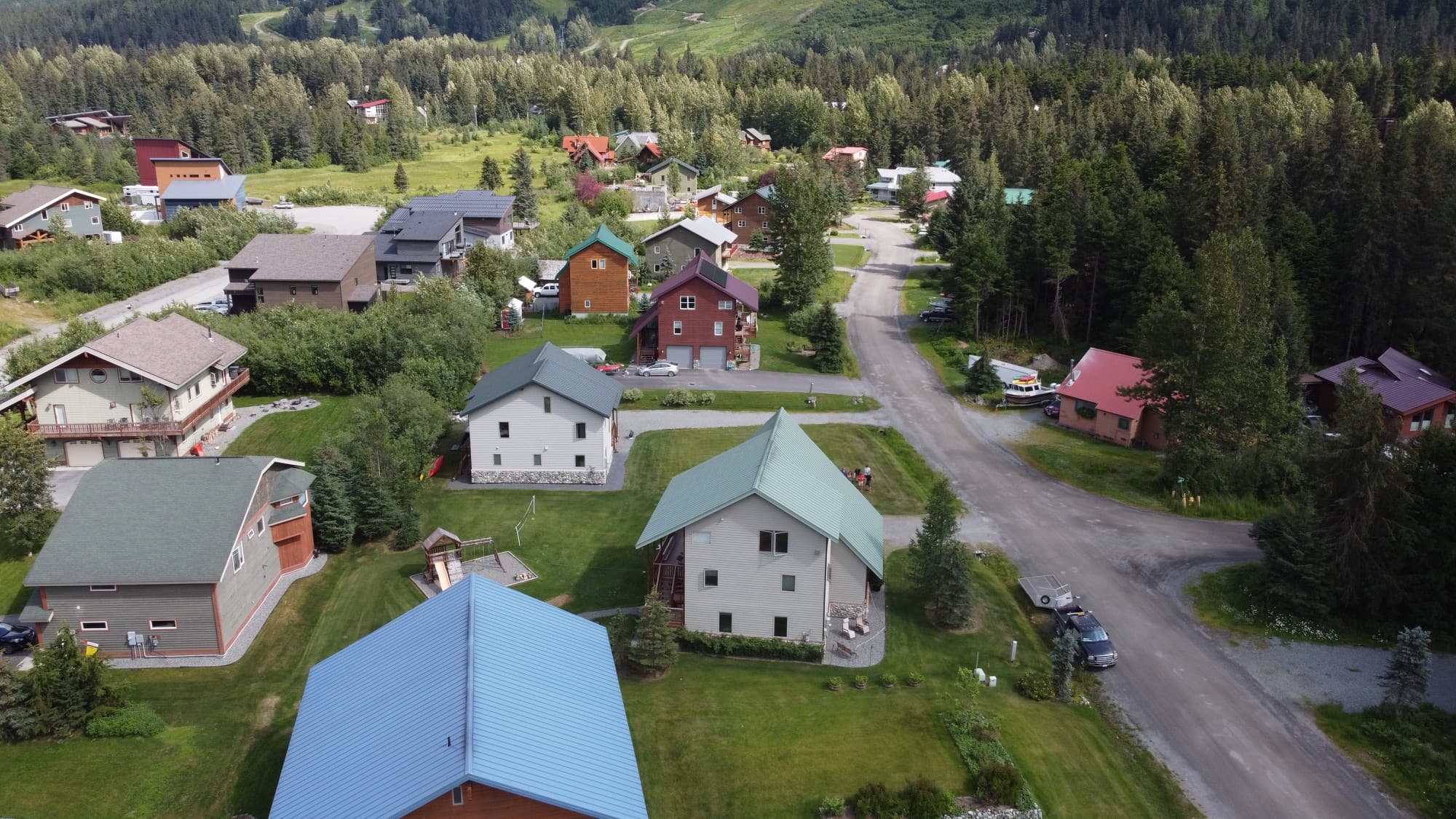 Aerial view of Girdwood homes with the green ski runs of Alyeska rising behind them