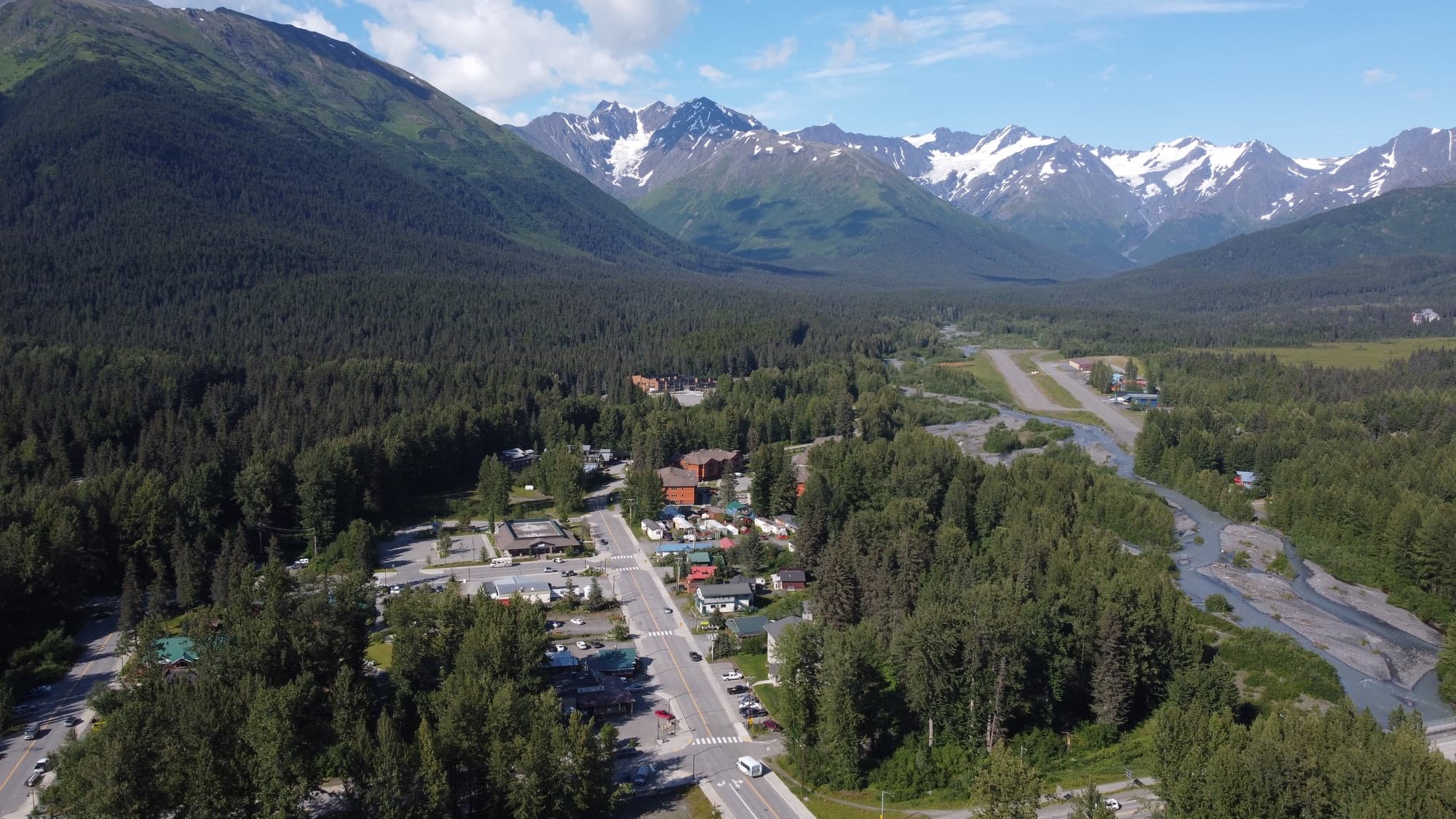 Aerial view of the Girdwood townsite in its valley, ringed by forest and glaciated peaks